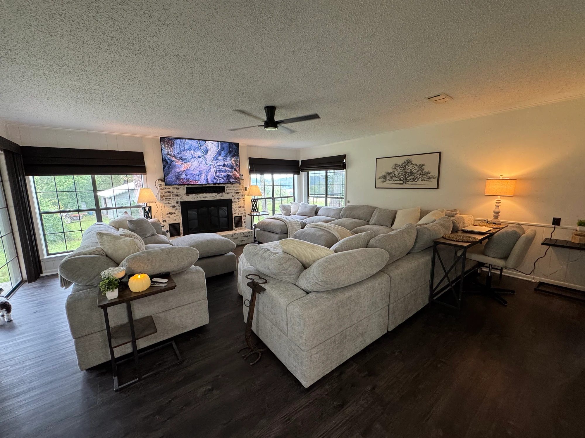 Living room with upholstered seating, fireplace and large windows